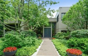 a house with a walkway and trees